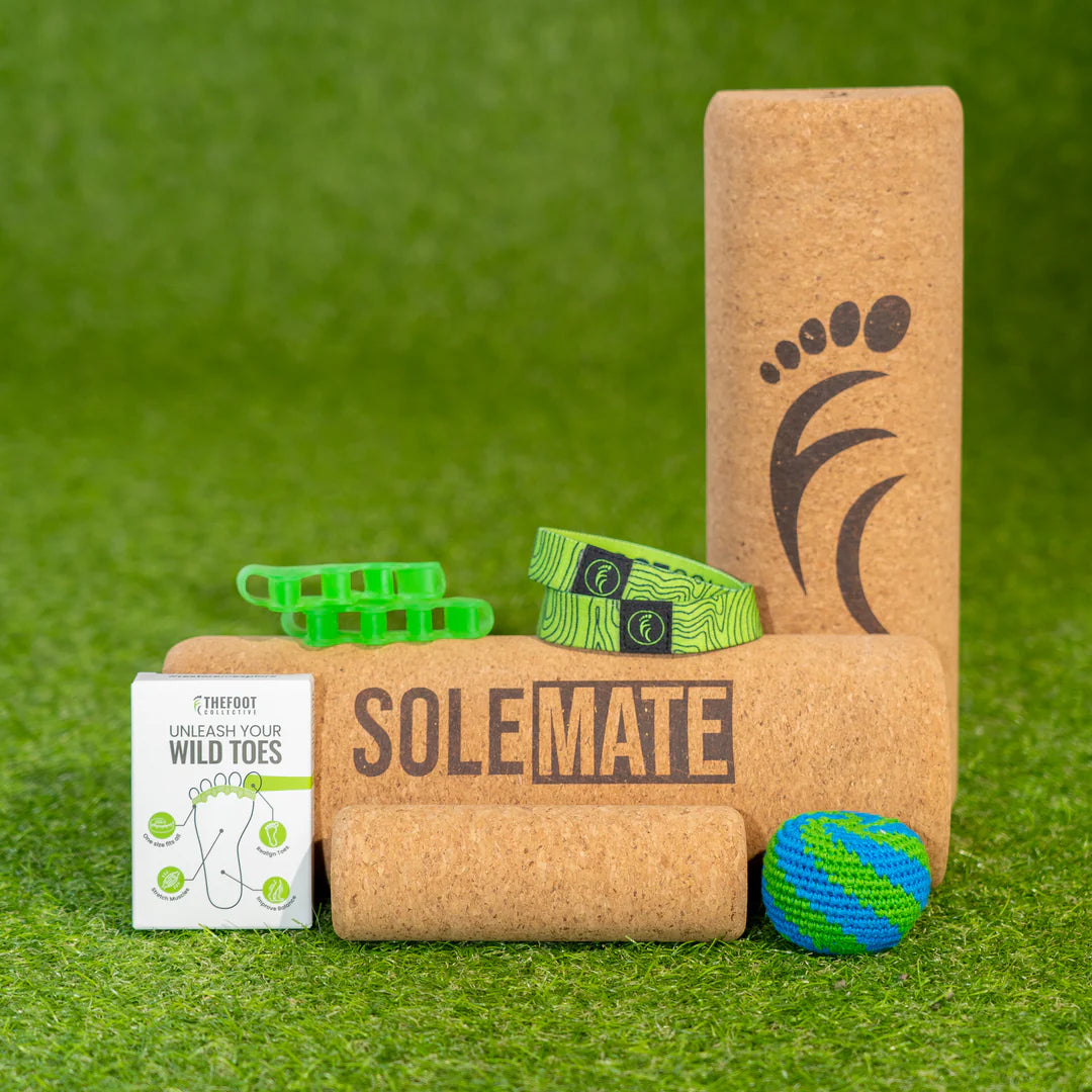 SoleMate Kit foot training tools including cork roller toe spacers resistance bands and massage ball on grass